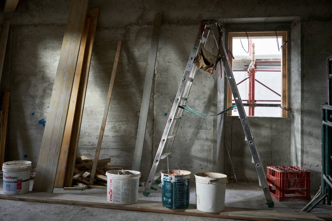 Habitación en obra con escalera y cubos de material